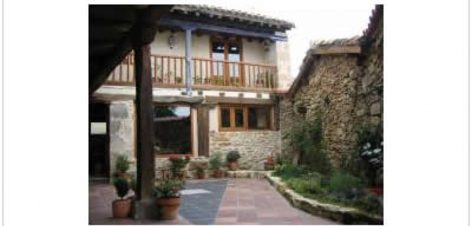 Casa de piedra con balconada, porch...